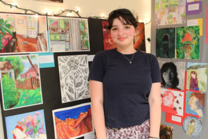  Student in front of their art exhibit